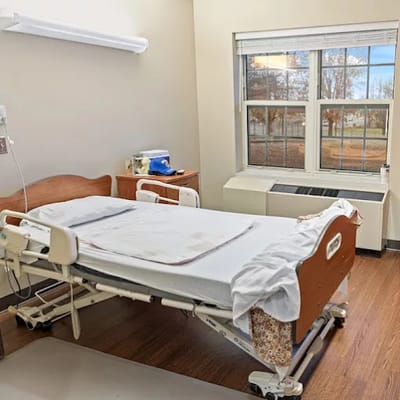 A private resident room with a hospital bed and window