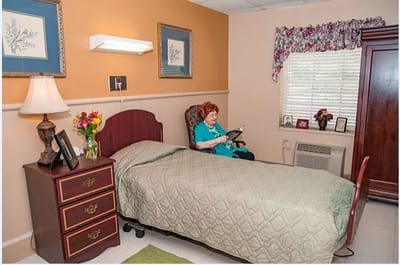 A resident reading in her room with personal touches