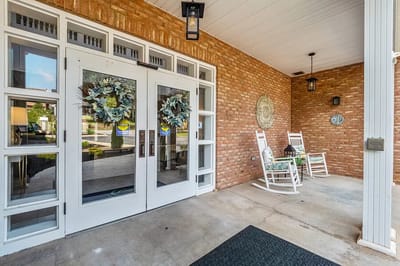 Exterior entrance of The Parker with rocking chairs.