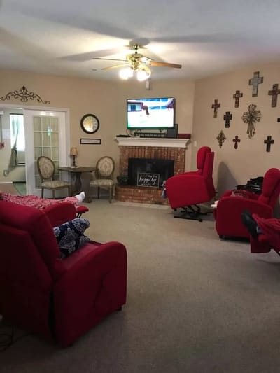 A cozy common area with red chairs and television