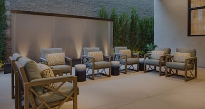 Outdoor seating area with lounge chairs and greenery