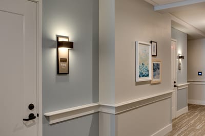 Brightly lit corridor with artwork and room number signage