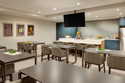 A modern cooking area with dining tables and kitchen appliances