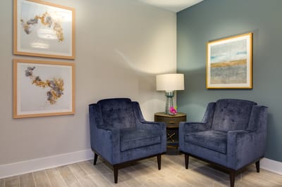 Cozy seating area with blue chairs and artwork
