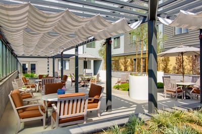 Outdoor seating area with shaded tables and chairs