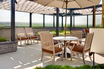 Outdoor seating area with shaded tables and chairs