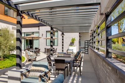 Outdoor seating area with shaded tables and chairs