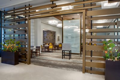 Entryway to a modern dining room with tables and chairs