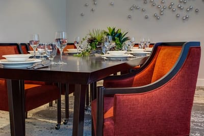 Elegant dining room setup with red chairs and tableware