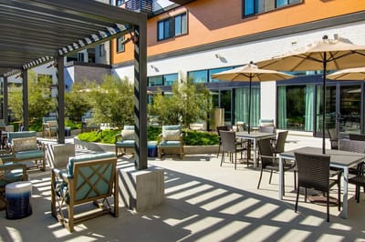Outdoor seating area with shaded tables and chairs