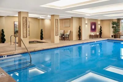 Indoor swimming pool area with seating and plants