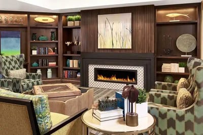 A cozy interior common area with a fireplace and seating