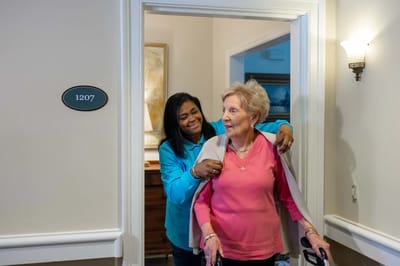 Staff assisting a resident in a hallway