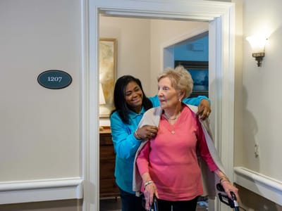 Staff assisting a resident in a hallway