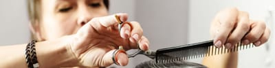 A stylist cutting hair in a salon setting