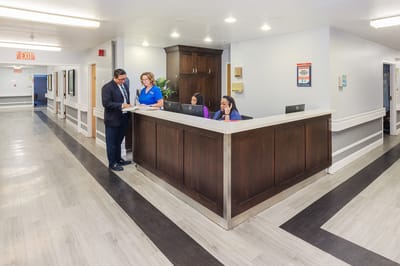 Reception area with staff attending to a visitor