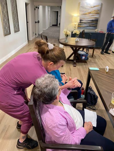 Staff assisting a resident in a cozy common area