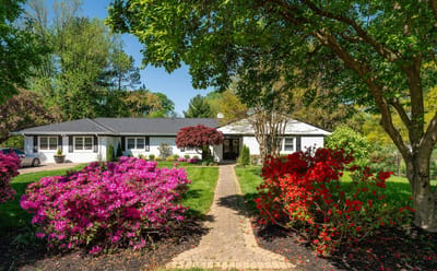 Exterior view of a residential facility surrounded by colorful flowers