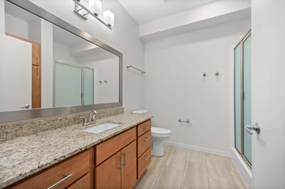 Modern bathroom with granite countertops and large mirror