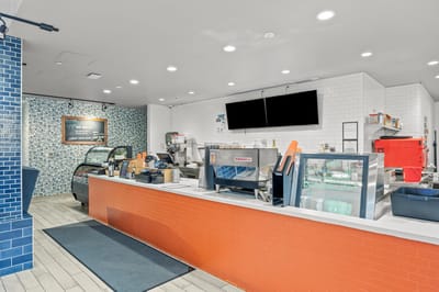 Bright cafe area with coffee counter and pastries