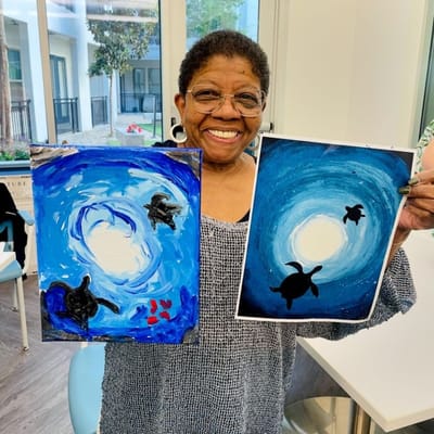 Resident showcasing her artwork in a common area