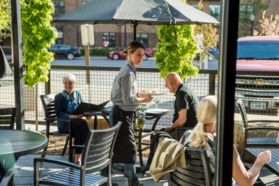 Outdoor dining experience with residents and staff serving food