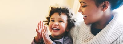 Mother laughing with child in a cozy setting