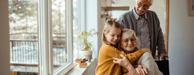 Synergy Homecare – New York, home care in New York, NY — Senior woman embracing young girl with smiling man behind