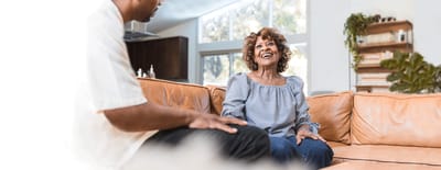 Senior woman smiling during conversation in a common area.