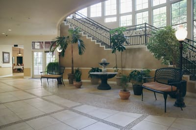 Lobby area with plants and seating near staircase