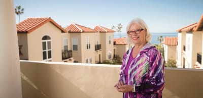 Resident smiling on a balcony with ocean view