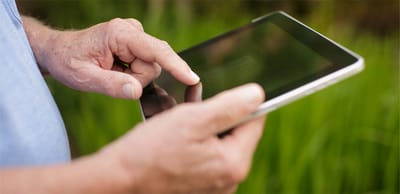 A person using a tablet in a green outdoor space