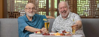 Two residents enjoying drinks and snacks in a common area