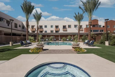 A serene outdoor pool area with palm trees and lounge chairs