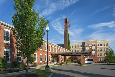 Exterior view of the facility with a bus and garden