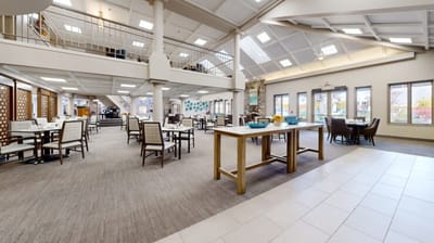 Dining area with tables and chairs in common space.
