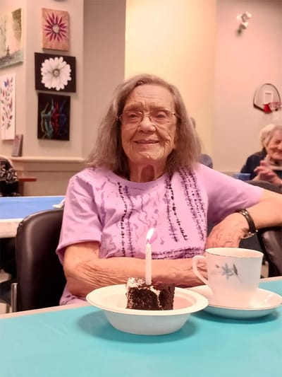 Resident celebrating with cake and coffee.