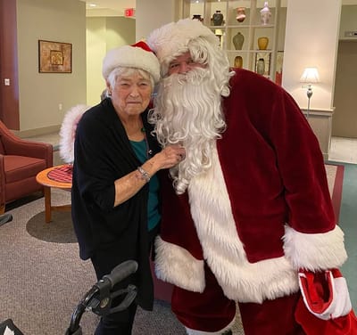 Resident and Santa celebrating in the common area