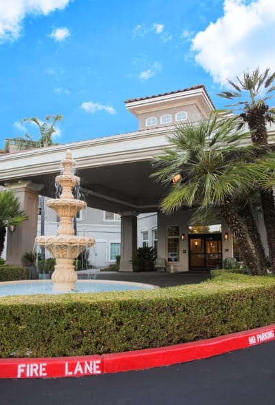 Exterior view of a nursing home entrance with fountain