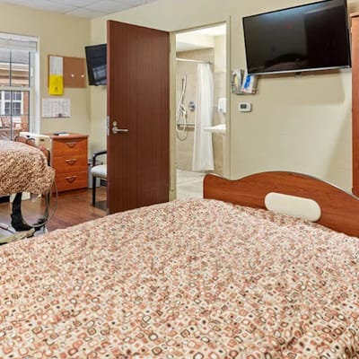 A shared resident room with two beds and a TV