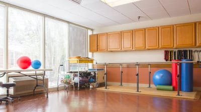 A well-lit activity room with exercise equipment