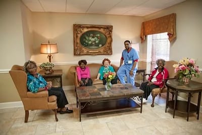 Residents and staff in a common area of the facility