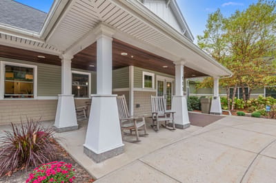 Covered outdoor area with rocking chairs and garden
