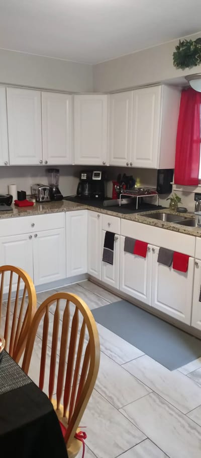 A kitchen interior with white cabinets and red accents