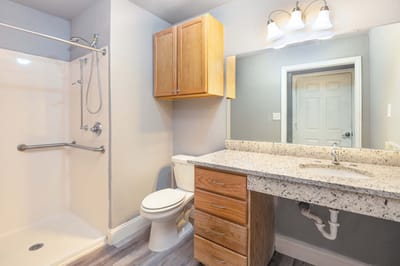 A well-lit, clean bathroom with a shower and vanity