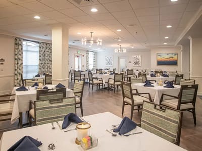 Dining room with set tables and blue napkins