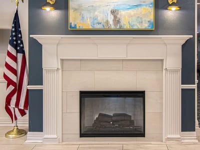 Interior view of a lobby with a fireplace and American flag