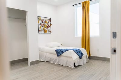 Bright and simple resident bedroom with a bed and decor