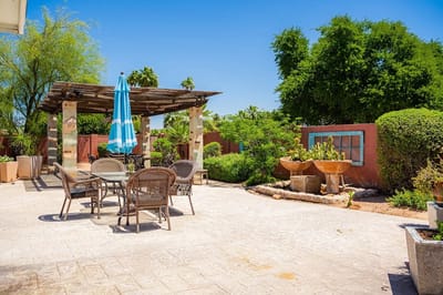 Outdoor patio area with tables and greenery