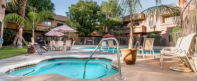 Swimming pool area with lounge chairs and umbrellas